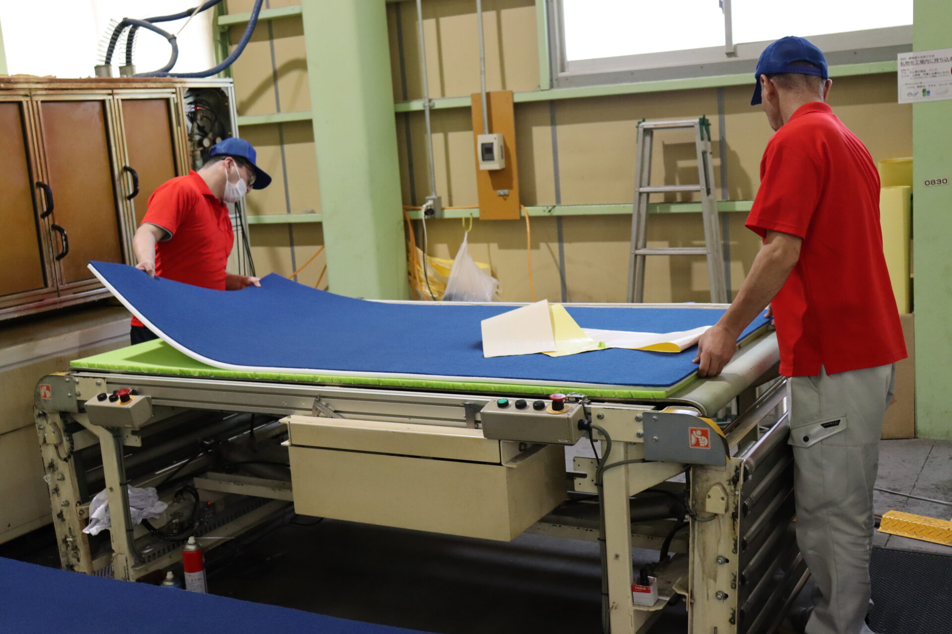 Technician laminating sponge and non-woven fabric by hand
