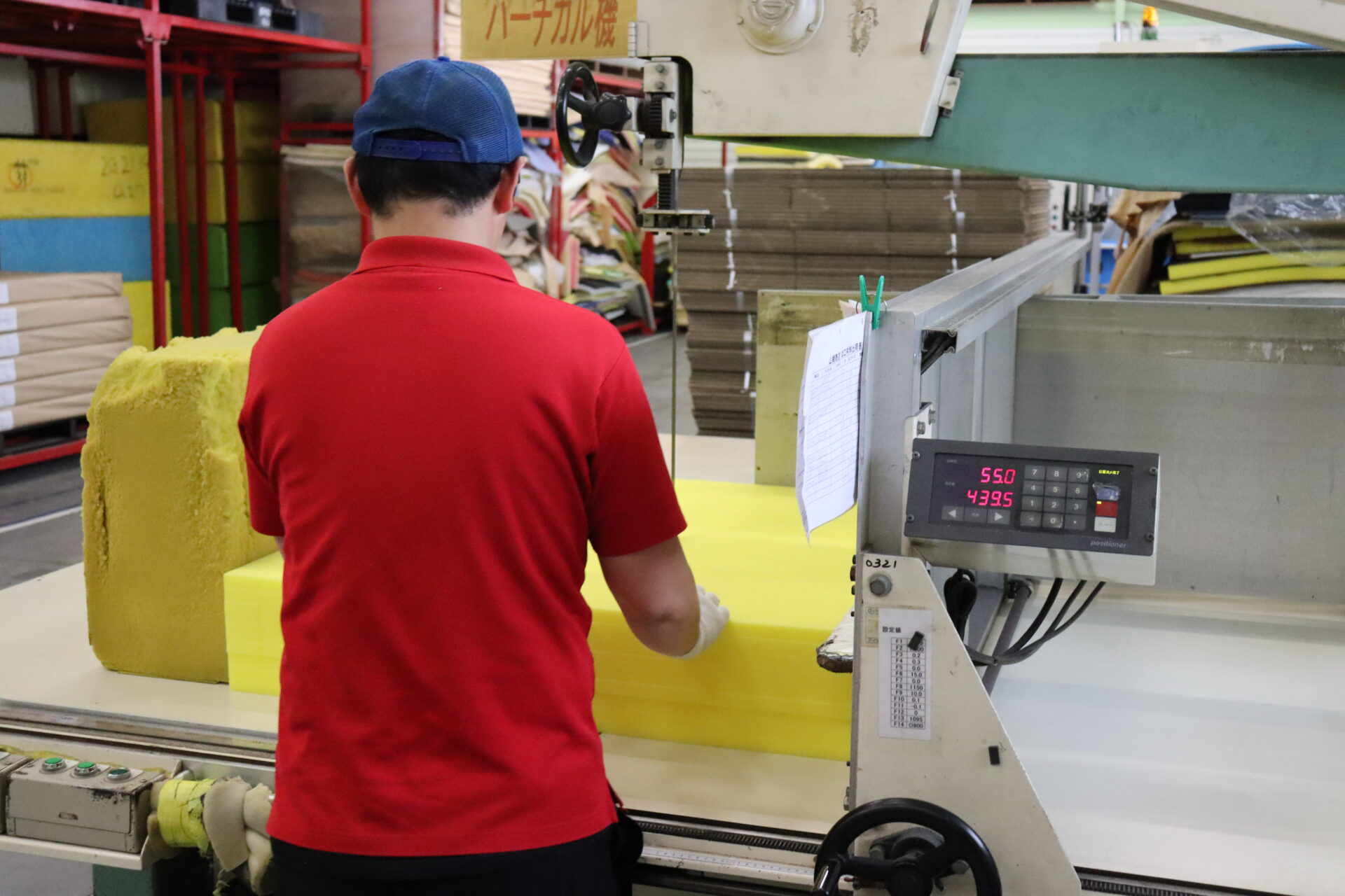 Vertical cutter slicing through a foam block